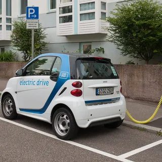 A small electric car plugged into a charging station